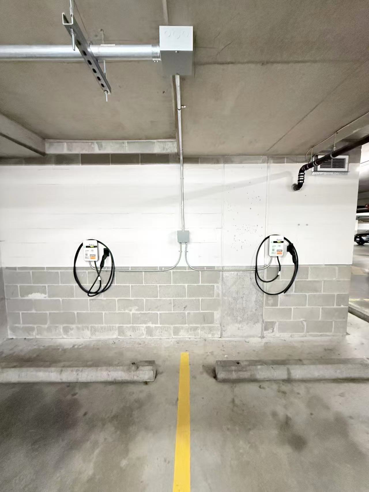 EV charging equipment installed along the wall of an underground parkade