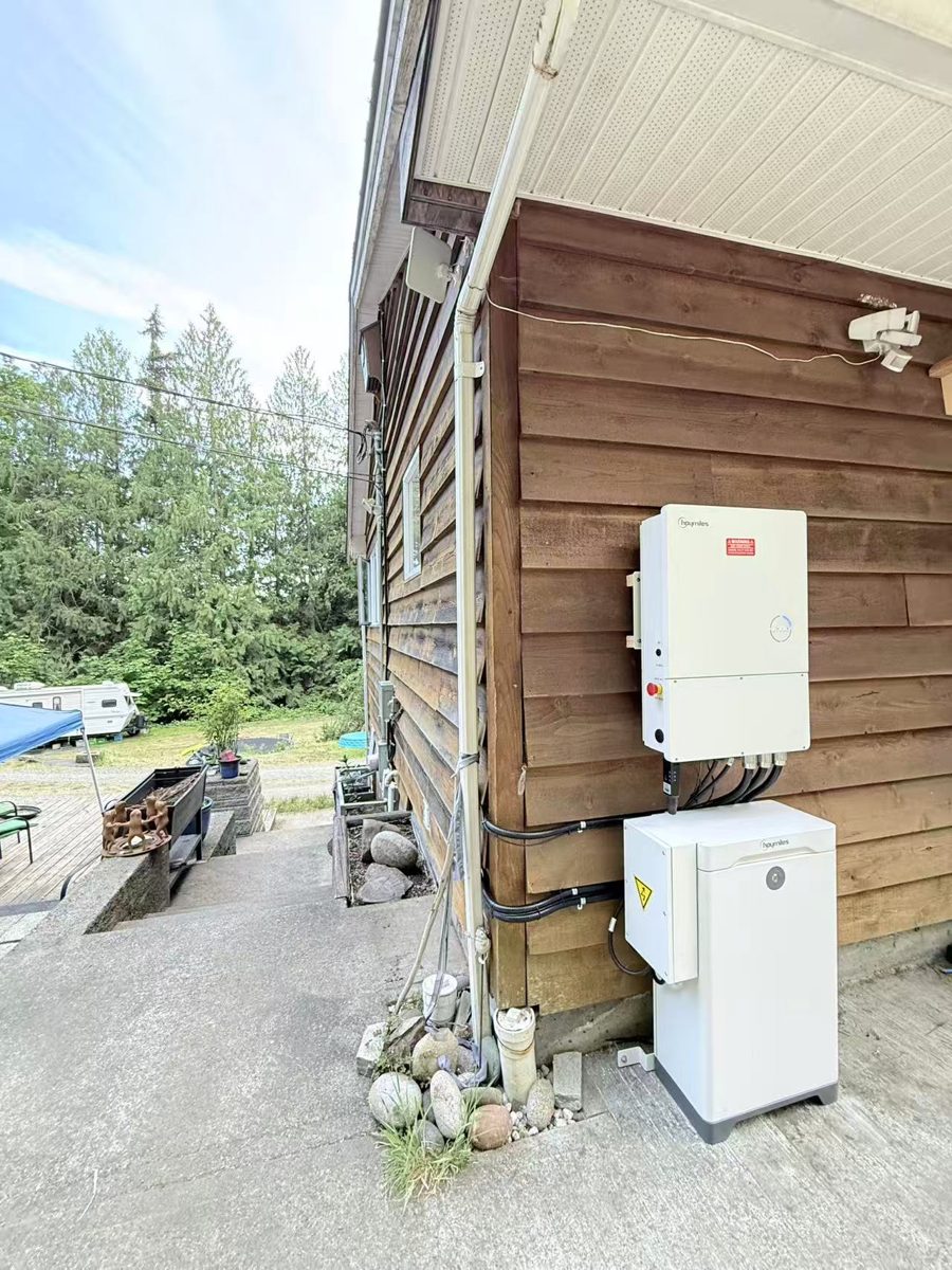 Hoymiles hybrid inverter and battery storage installed on a wood-sided exterior wall